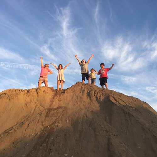 Kids playing on a mound of dirt