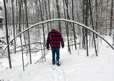 Man in Black and Red Flannel Hiking through Snow in St. Albans, Vermont