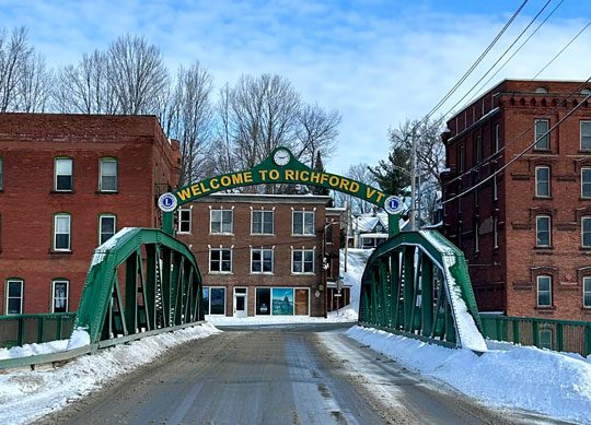 Green metal bridge with a Welcome to Richford, VT sign above it